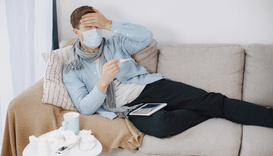 sick-guy-in-living-room-middle-age-man-feeling-sick-with-cold-and-fever-at-home-man-in-medical-mask